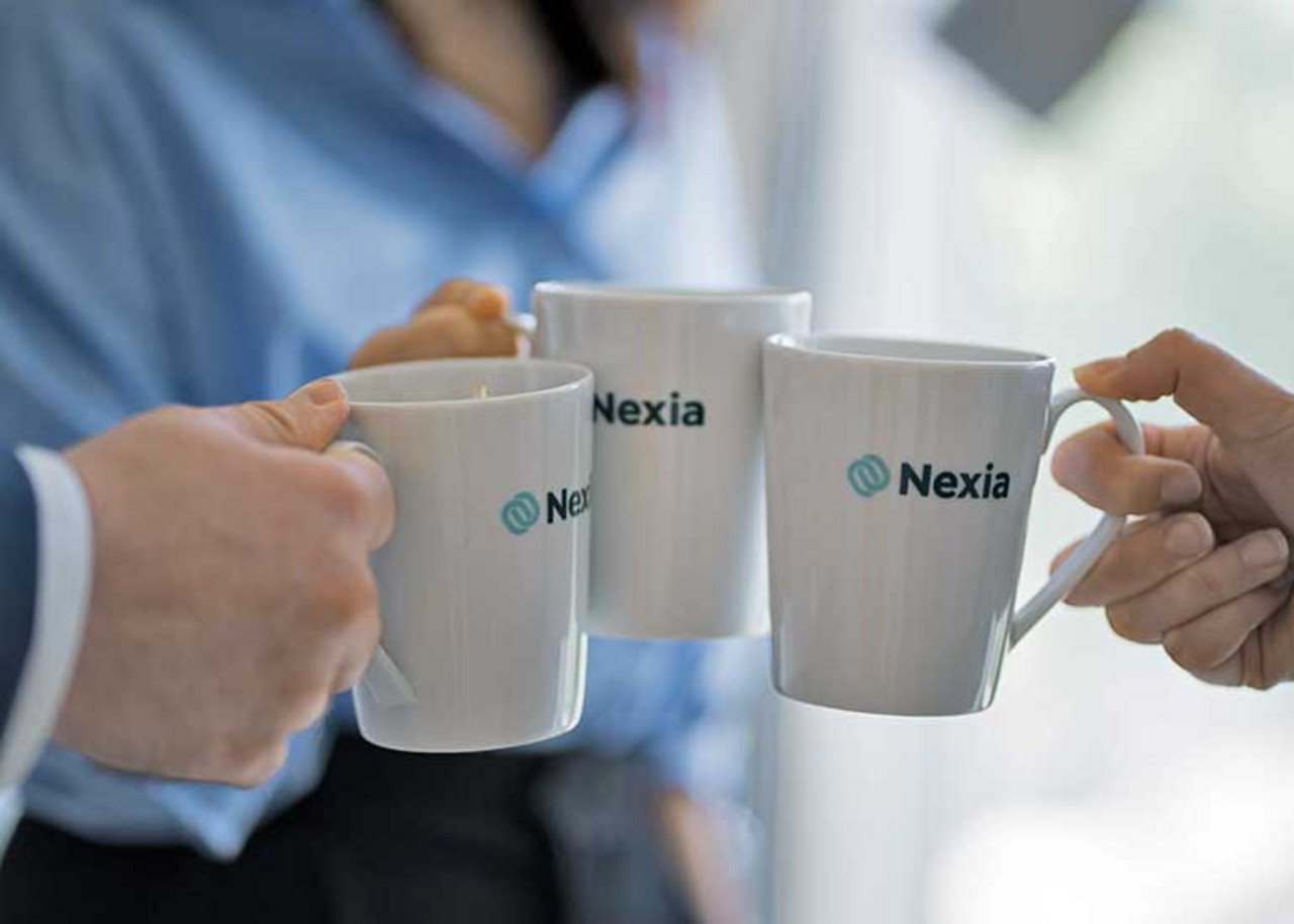 Recruitingteam Drei Personen stoßen mit Kaffeetassen an.