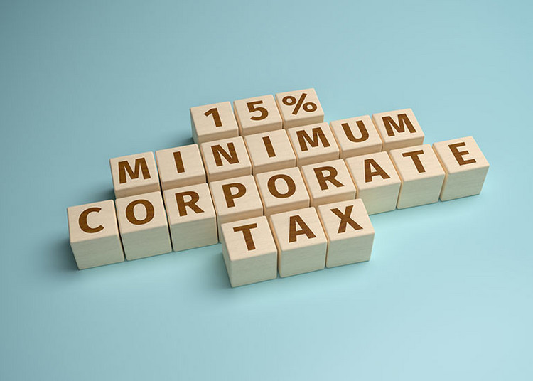 Mit Bauklötzen ist der Text „15% Minimum Corporate Tax“ geschrieben. Jeder Buchstabe ist auf einem einzelnen Bauklotz.