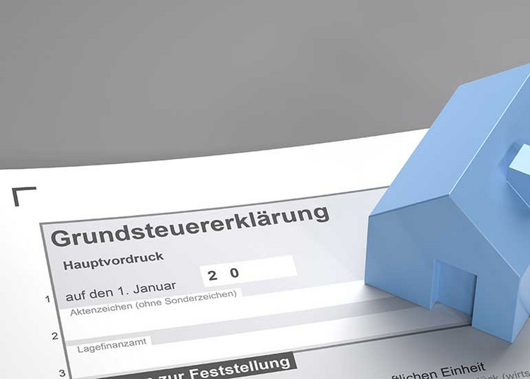 Formular für die Grundsteuererklärung.  Auf dem Formular steht ein Modell eines Hauses.