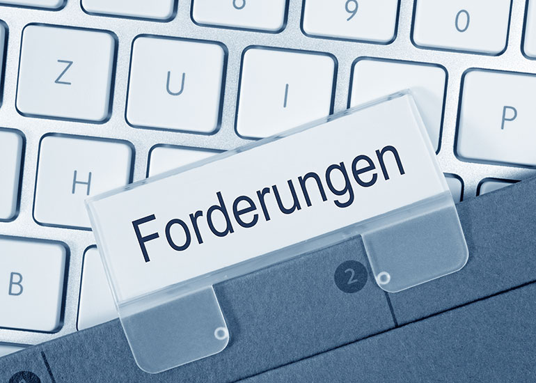 Auf einer Tastatur befindet sich ein Register mit der Aufschrift "Forderungen".